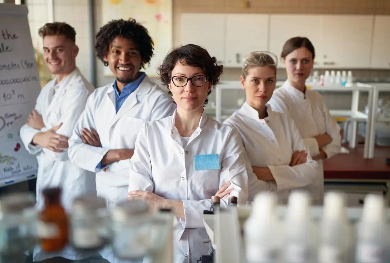 Group of scientists posing together in lab, showcasing organizational solutions.
